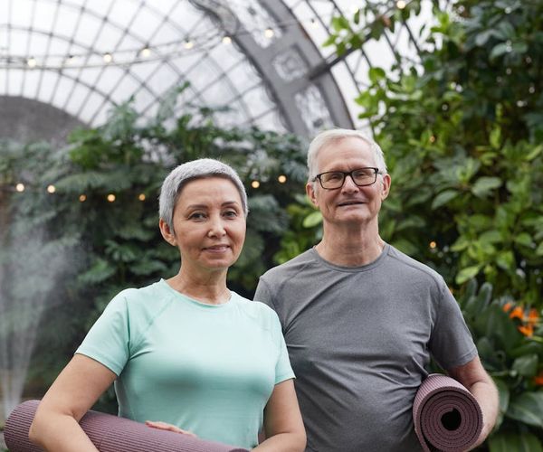 Diverse group of women smiling and holding yoga mats.