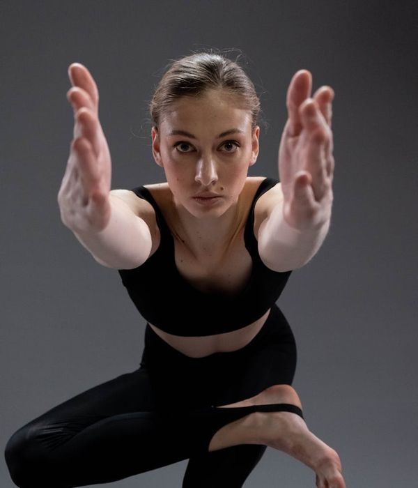 Woman in a calm yoga pose against a dark, serene background.